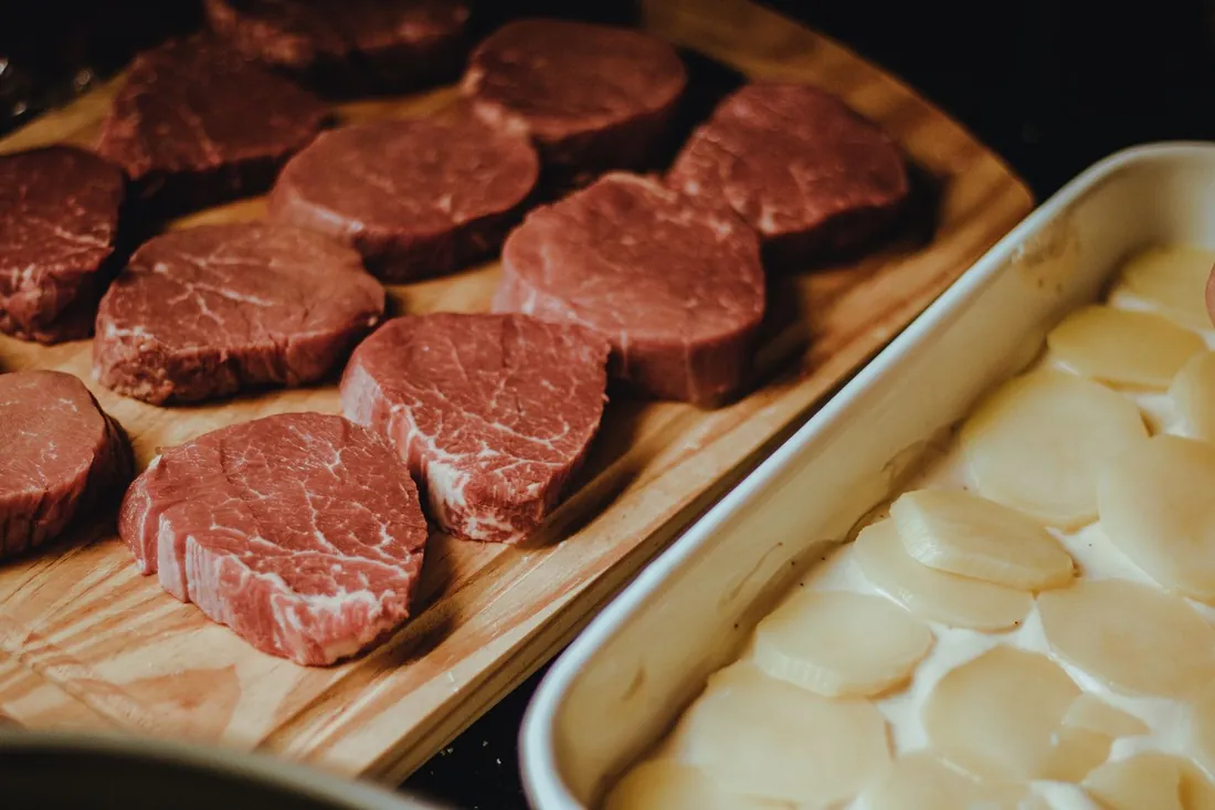 A wooden tray of thick-cut, well-marbled fillet steaks ready at the counter.